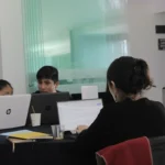 Estudiantes universitarios latinoamericanos trabajando con laptops.