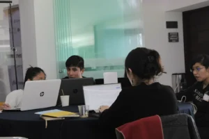 Estudiantes universitarios latinoamericanos trabajando con laptops.