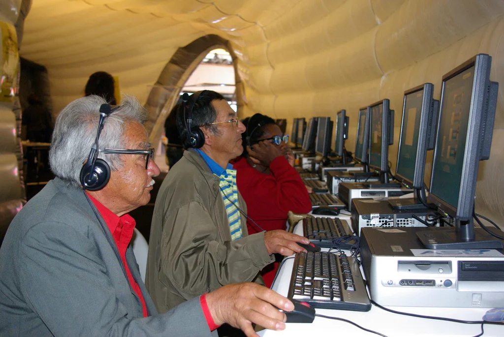 Jóvenes con computadoras en un evento de tecnología en América Latina.