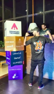 Asistente con la camiseta de Bitcoin Dominicana frente a los cubos de patrocinadores de Dominicana Tech Week 2026.