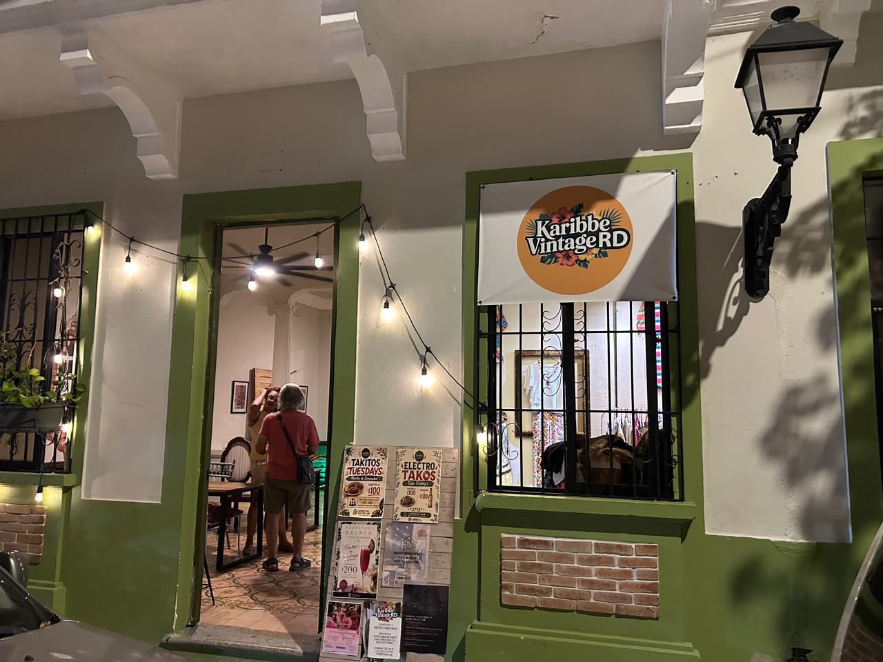 Fachada verde de The Perpetual Lab con el cartel de Karibbe Vintage RD y afiches de eventos en la Zona Colonial de Santo Domingo