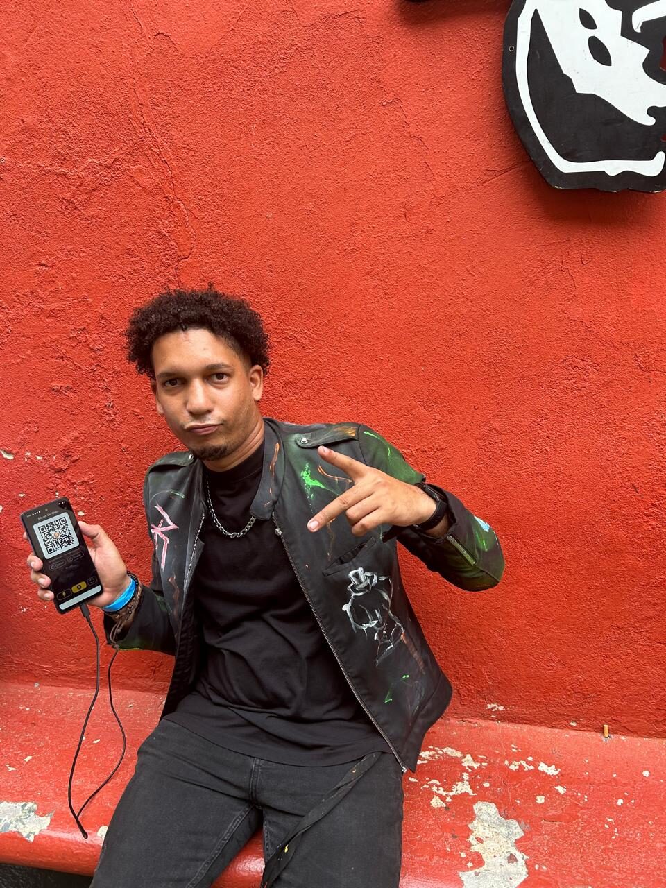 Joven artista mostrando su billetera Bitcoin en República Dominicana