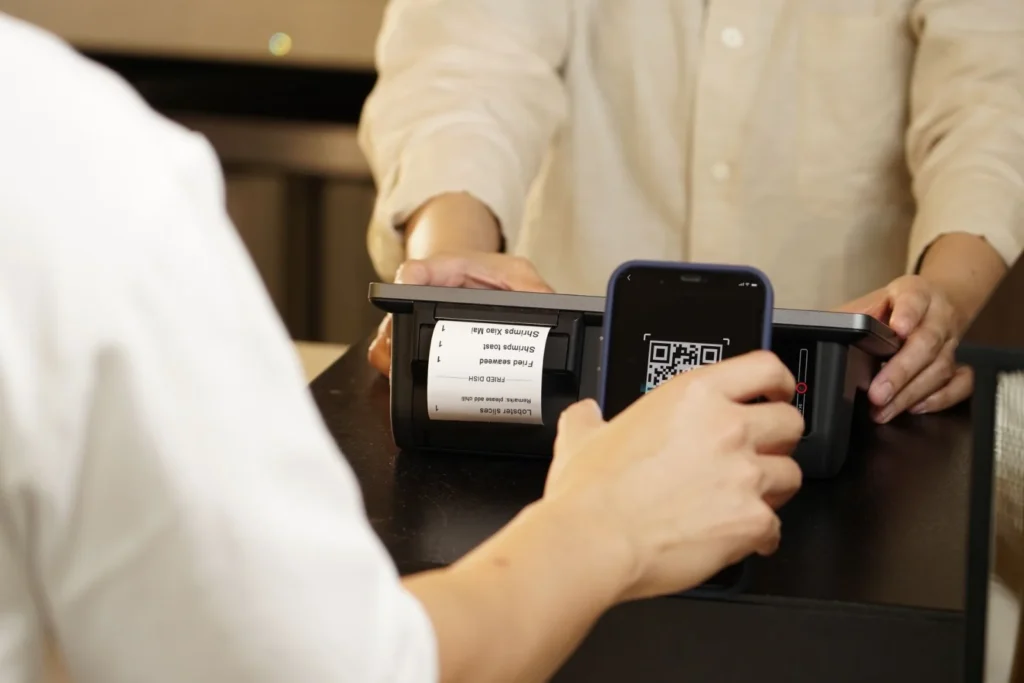 Cliente pagando con código QR en el mostrador de un comercio