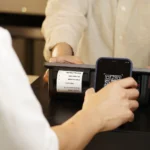 Cliente pagando con código QR en el mostrador de un comercio