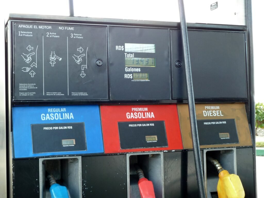 Surtidor de combustible en Santo Domingo con etiquetas de precio por galón en pesos dominicanos para gasolina regular, premium y diésel.