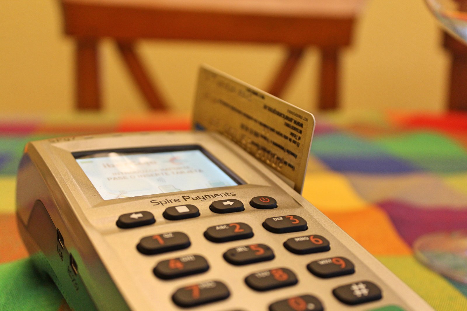 Terminal de pago con una tarjeta bancaria insertada y la pantalla en español.