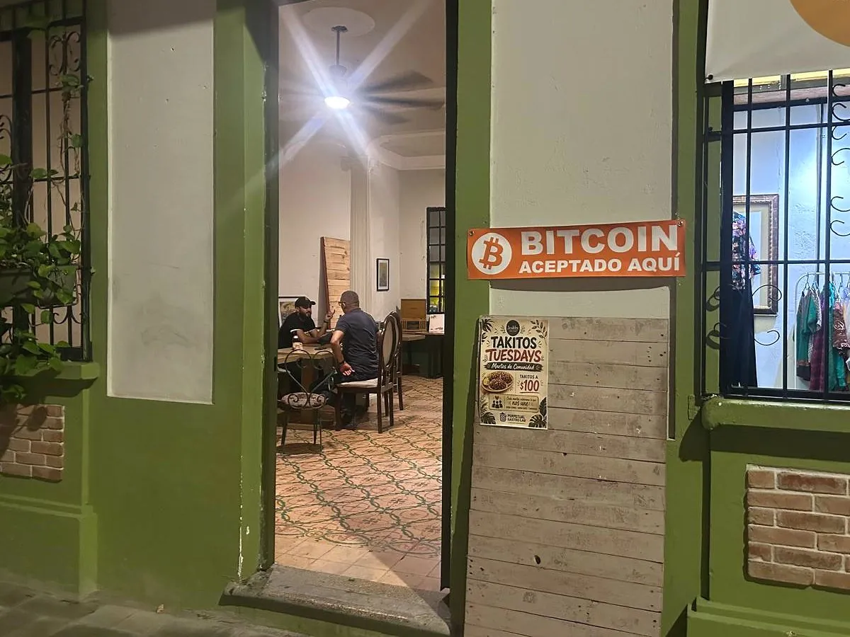Entrada de The Perpetual Lab en la Zona Colonial con el letrero naranja «Bitcoin aceptado aquí» junto a la puerta