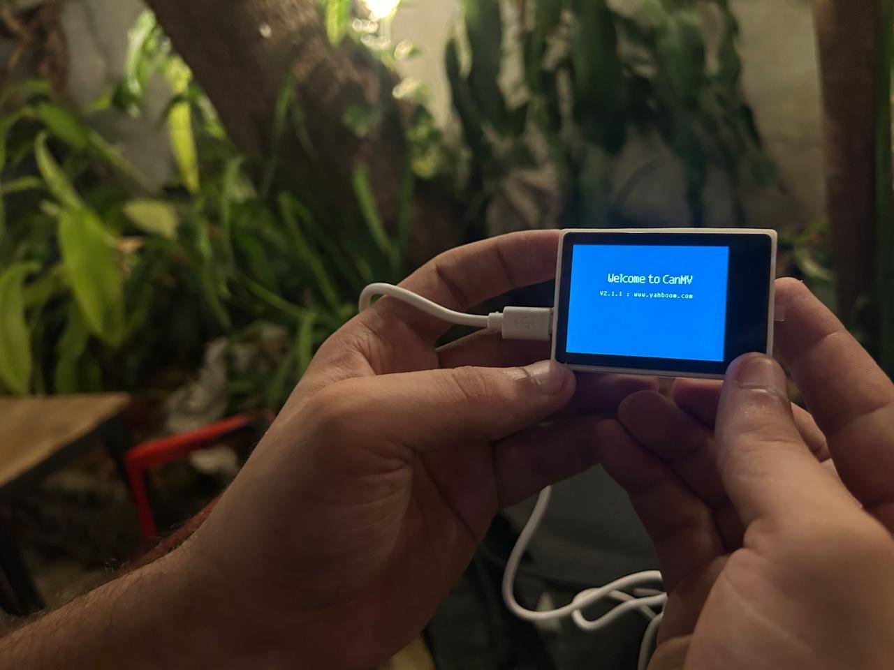 Manos sosteniendo un dispositivo con la pantalla de inicio encendida